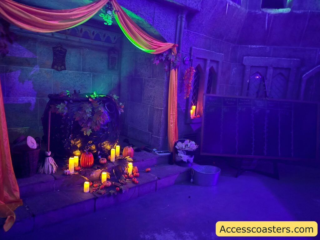 Corner of the witch area, decorated with flickering candles, draped fabrics, and glowing magical props.