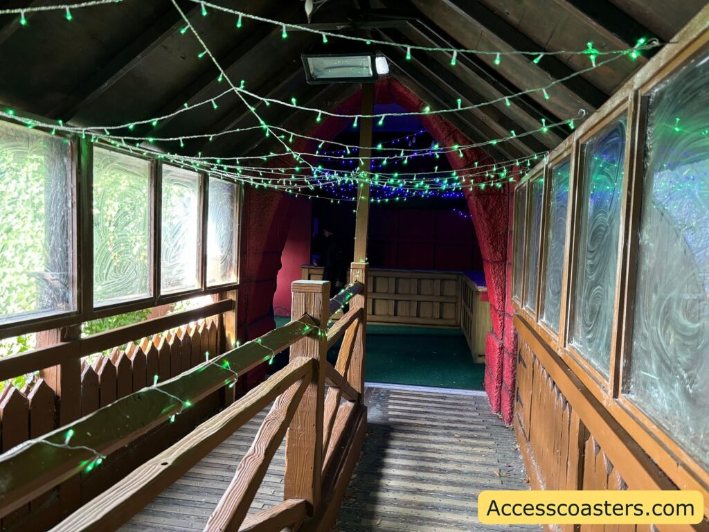 Castle corridor strung with green fairy lights, leading toward the exit. 
