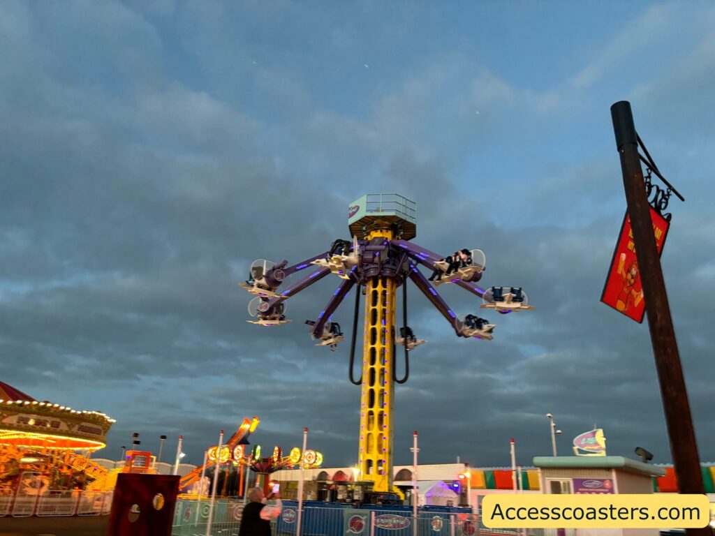 The Lightning 360 ride elevated high, with several arms and ride vehicles spinning in the air 