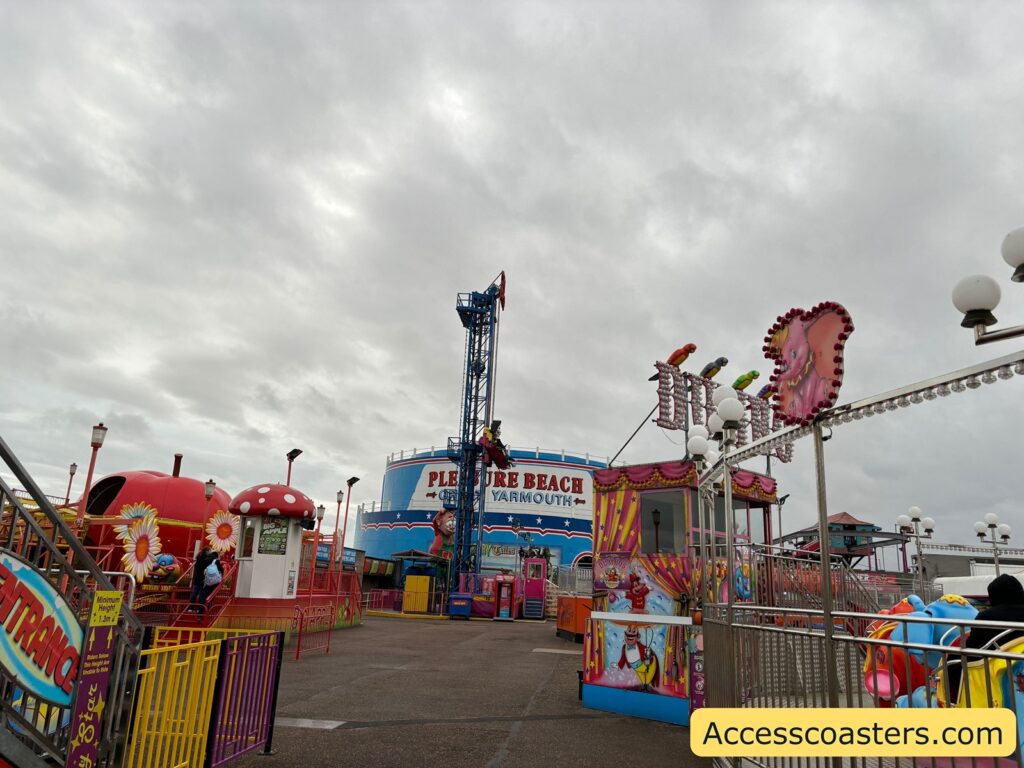 A wide view of the amusement park area around the Sky Drop ride, with the drop tower visible among other attractions.