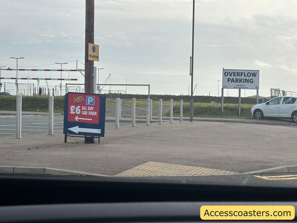  sign in the parking area showing “£6 All Day Car Park” with accessible spaces nearby 