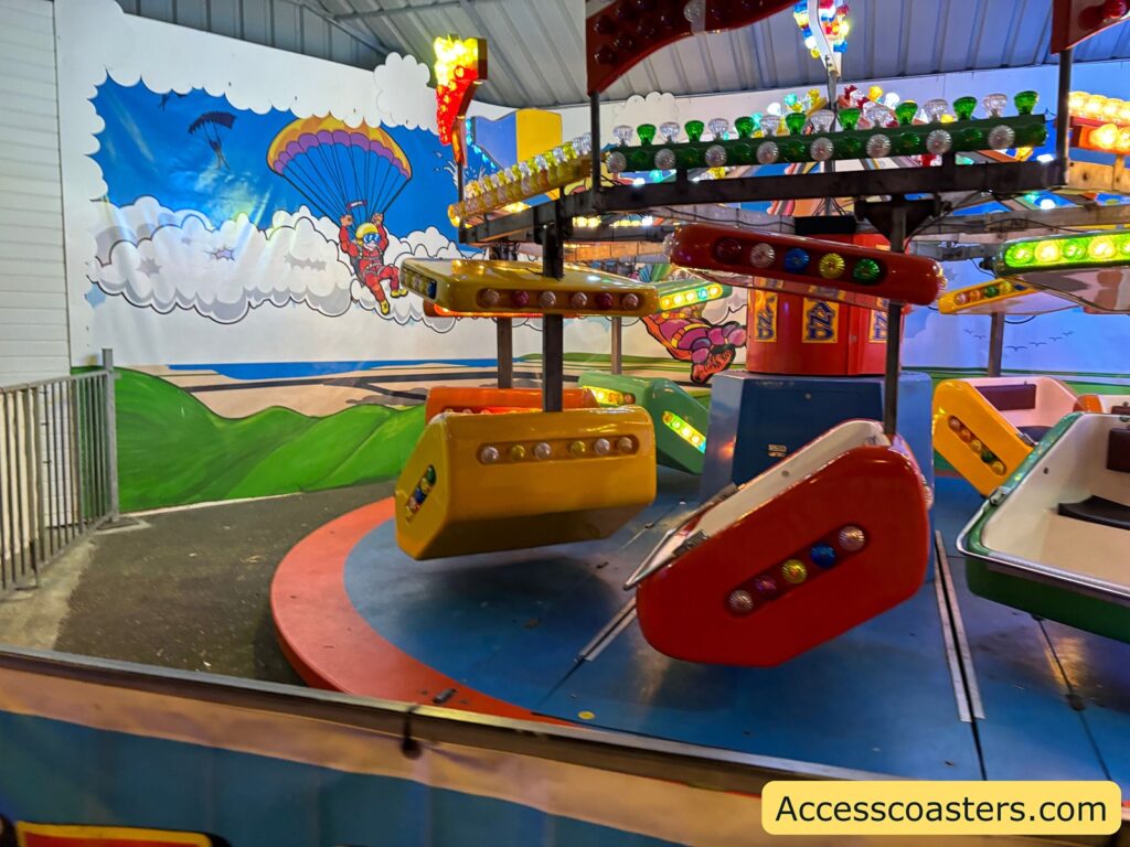 Colorful ride with small vehicles on arms — caption: Skydiver