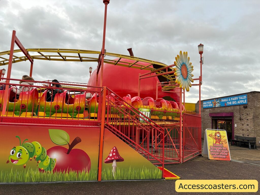 Big Apple Coaster ride structure  with train going around track. 