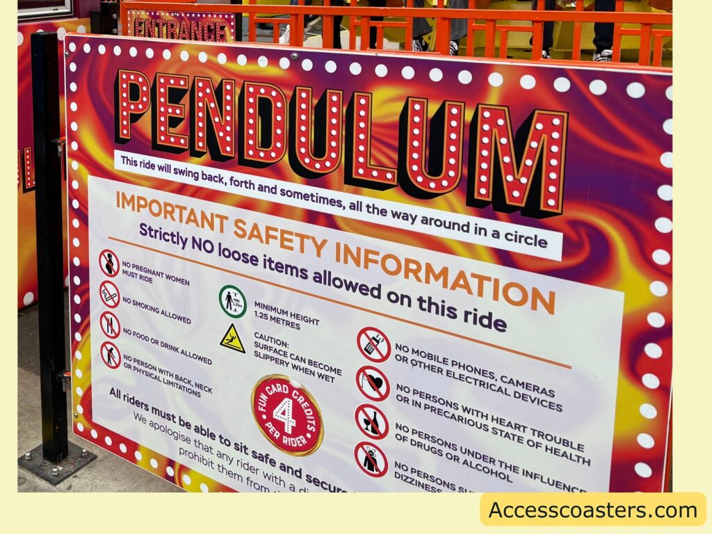 A close-up photo of the Pendulum ride’s safety information sign. The sign is brightly colored with the word "PENDULUM" at the top and lists important safety instructions