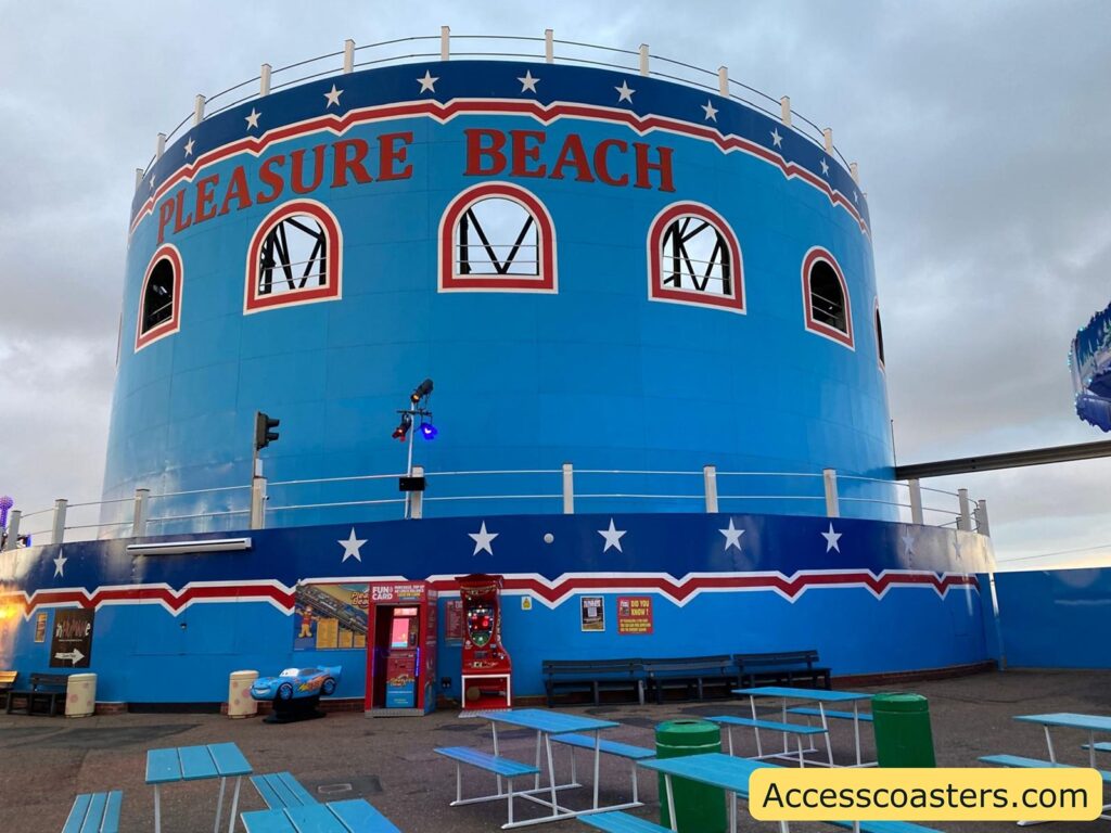 Outside view of the large, blue circular Roller Coaster building with decorative windows.