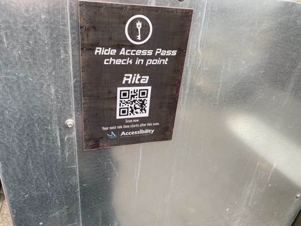 Close-up of a “Ride Access Pass” check-in point sign for RITA, with a QR code.