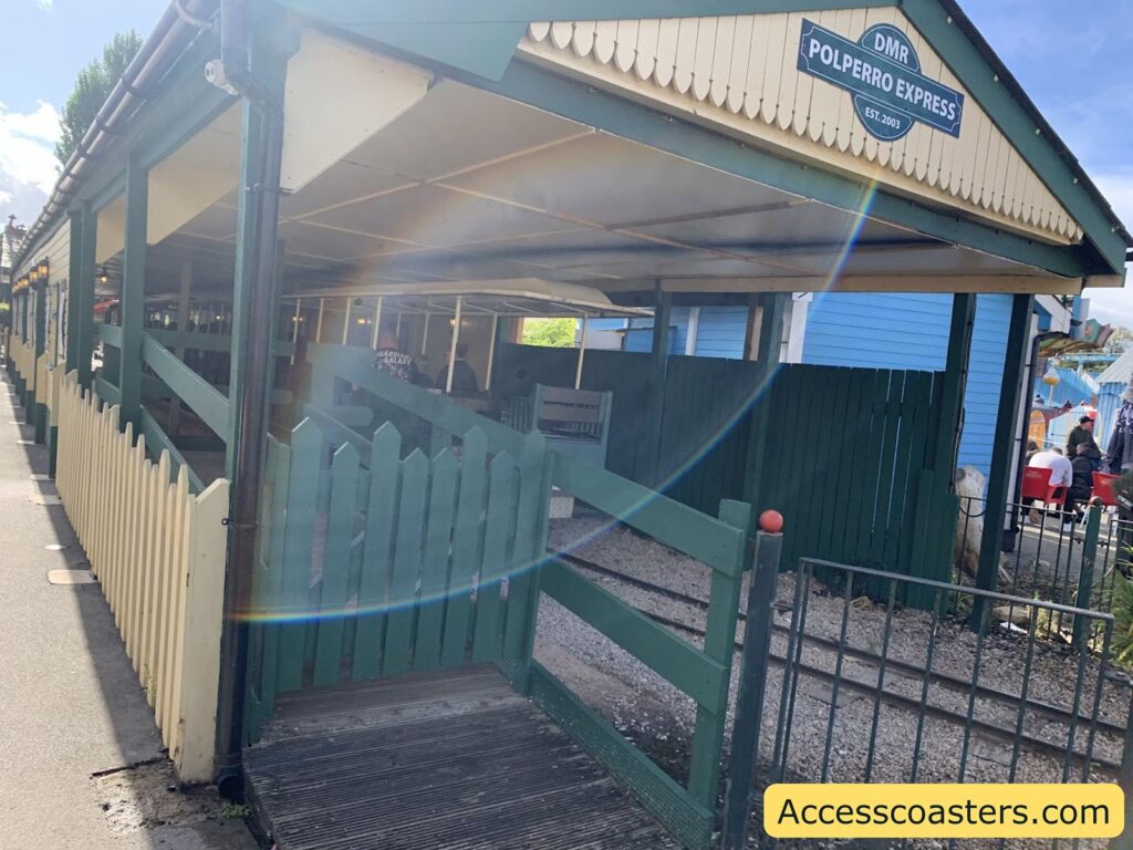  Entrance to a small train station with ramp access, suitable for wheelchair users.