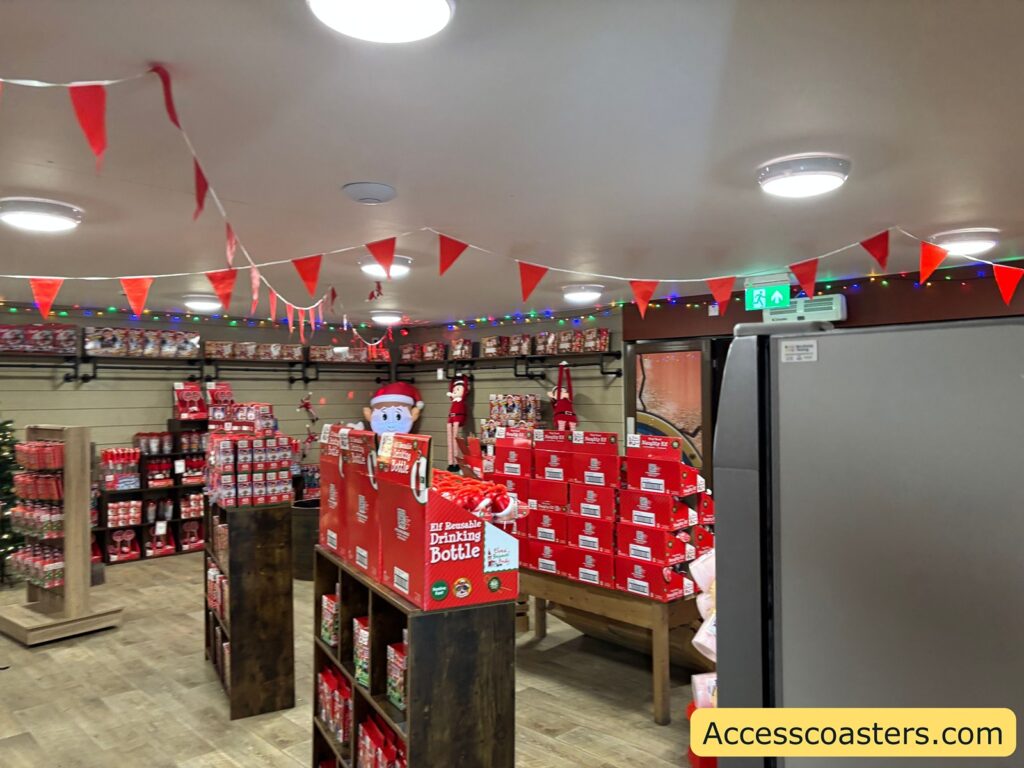 Interior of a gift shop brightly decorated for Christmas, shelves filled with Elf on the Shelf merchandise and festive bunting hanging from the ceiling.