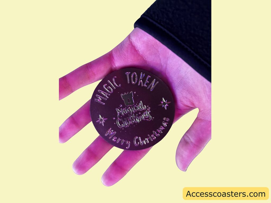 Hand holding a “Magic Token” coin, which is exchanged for a hot chocolate.