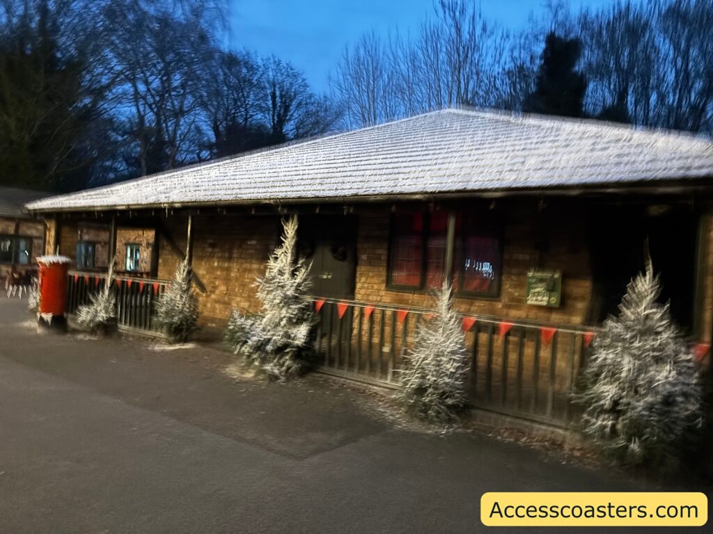  The Santa’s grotto building in the evening, lit up and surrounded by wintery decorations.