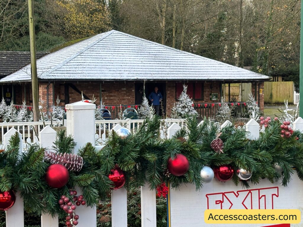  Outside view of the festively decorated Santa’s grotto building with garlands and baubles.