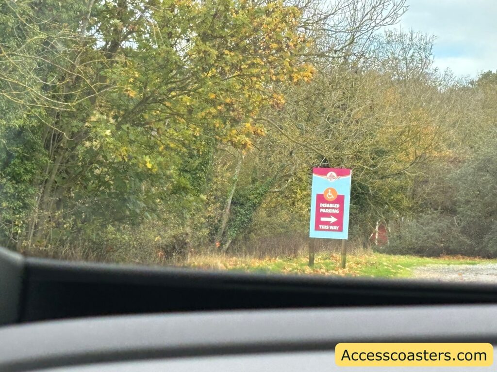 Photo taken from inside a car showing direction  sign for disabled parking