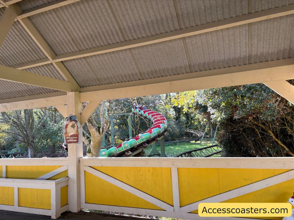 Egg Spress ride loading platform with bright yellow railings and sheltered roof.
