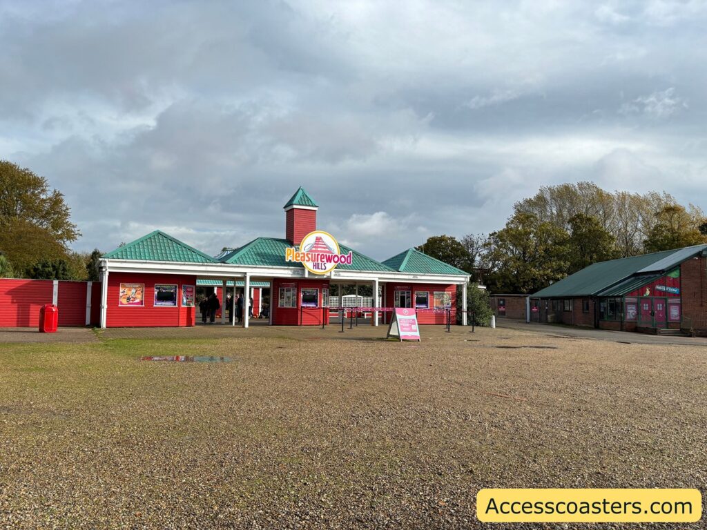 Wide view of the park entrance building and surrounding car park area.
