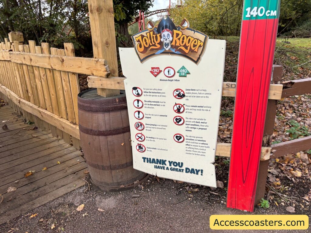  Close-up of the ride’s entrance sign and safety information board, with a height measurement post next to the path.