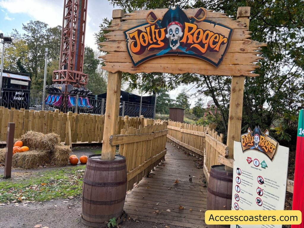 Entrance to the Jolly Roger drop tower ride, showing the wooden archway sign and ramp leading to the ride area.