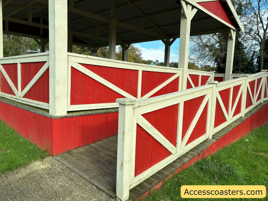 Covered picnic area with red and white fencing, providing step-free access.