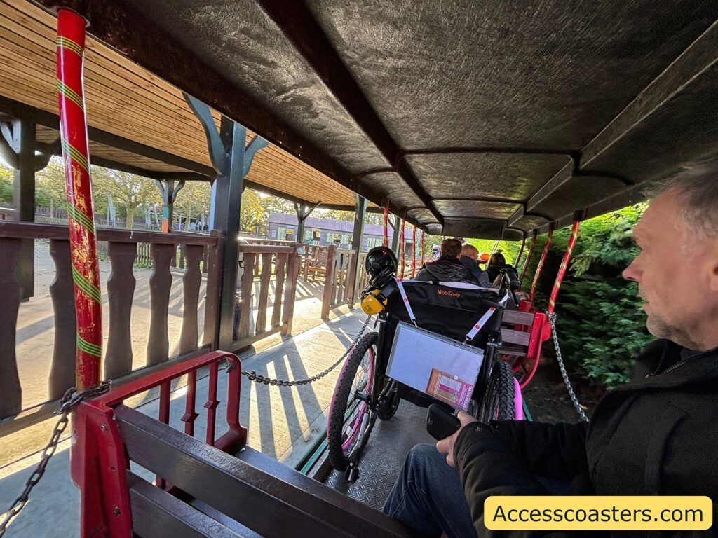  Inside view of the Pleasurewood Hills Express train, including a wheelchair user in a designated area.