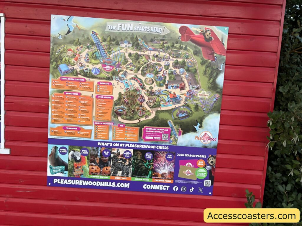 Large illustrated map and information board mounted on a red wooden wall outside the entrance.