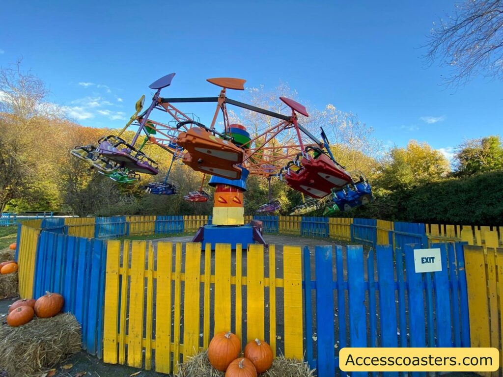 Side view of the Kite Flyer ride in operation, with the ride vehicles lifted off the ground