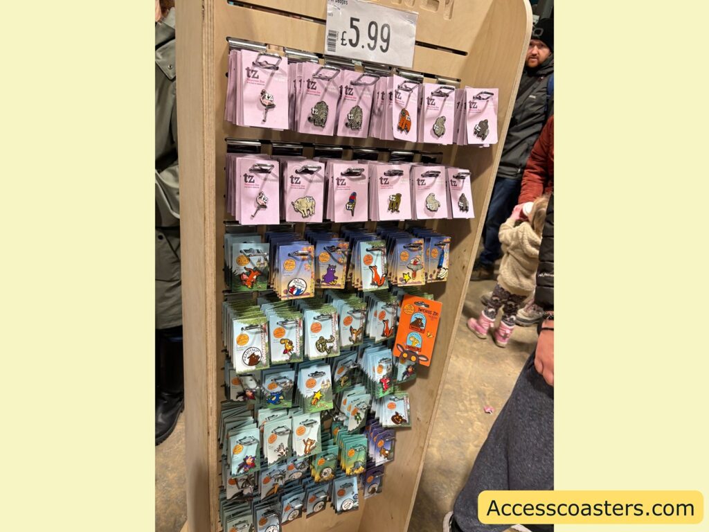 Gift shop display rack of animal-themed pin badges  priced £5.99.
