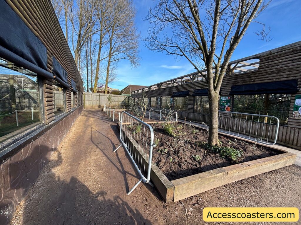 Accessible zoo pathway with handrails running alongside animal enclosures.
