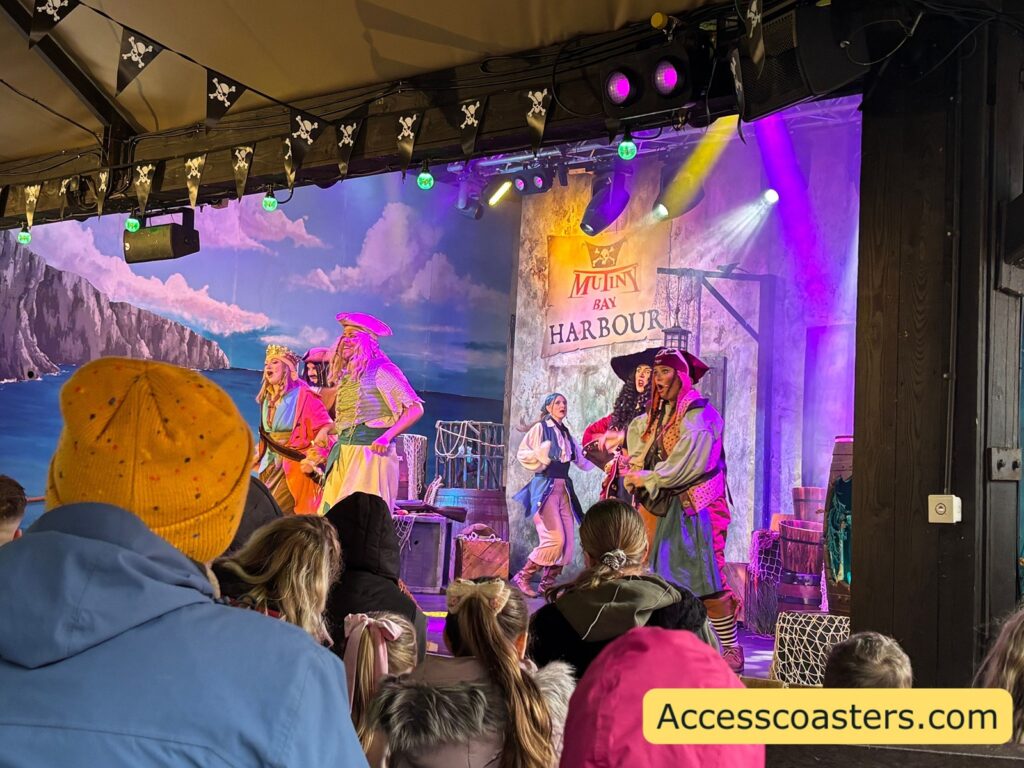 Pirates of Mutiny Bay: The Haunt for the Crown of T’Hulu onstage with multiple pirate characters performing under bright, colorful lights