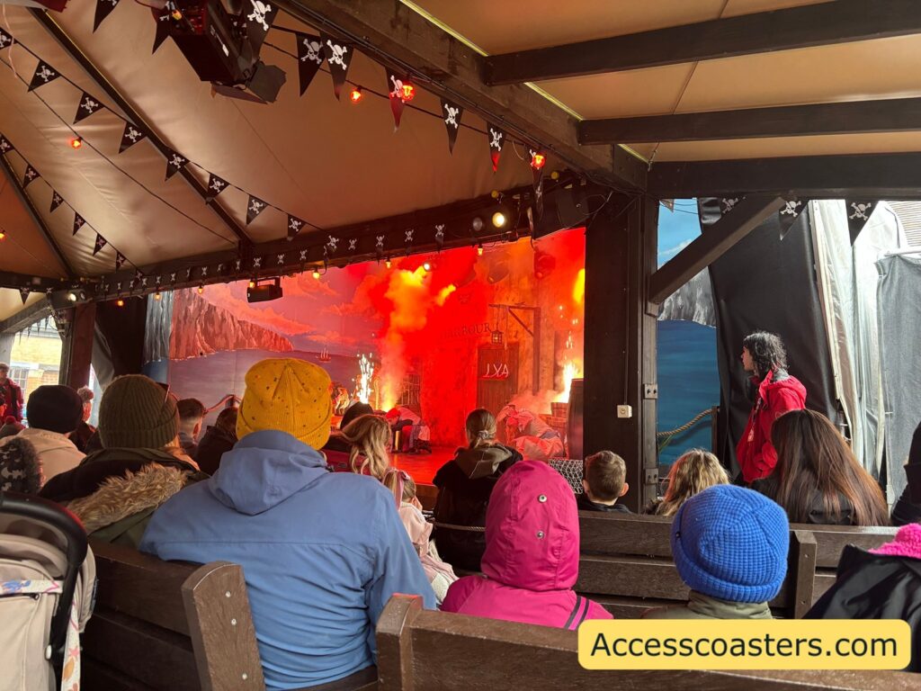 A key sensory moment in Pirates of Mutiny Bay: the stage glows orange-red with loud sound effects and smoke, showing the intense lighting used when “the crown of T’Hulu” is mentioned.