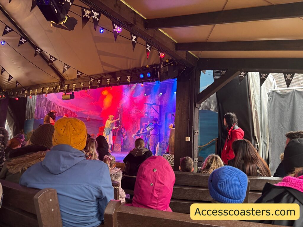 sensory-heavy scene from Pirates of Mutiny Bay: The Haunt for the Crown of T’Hulu, with orange and purple strobe-like lighting and smoke effects onstage.