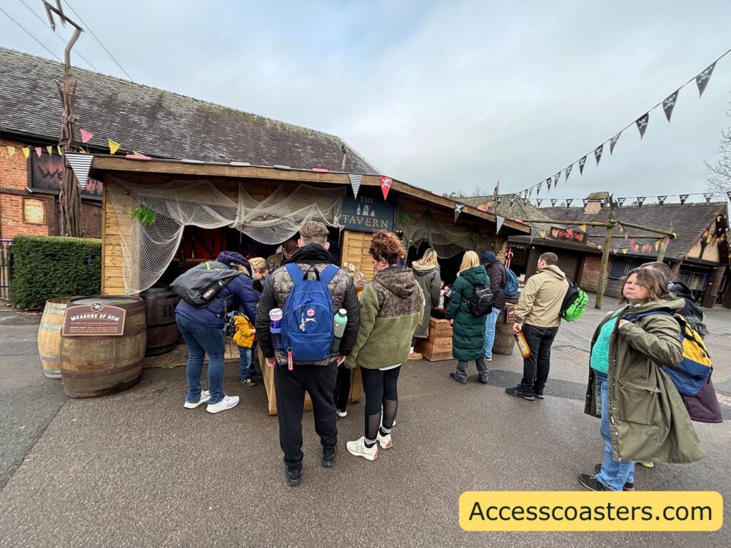 A larger crowd outside the hut area under strings of bunting.