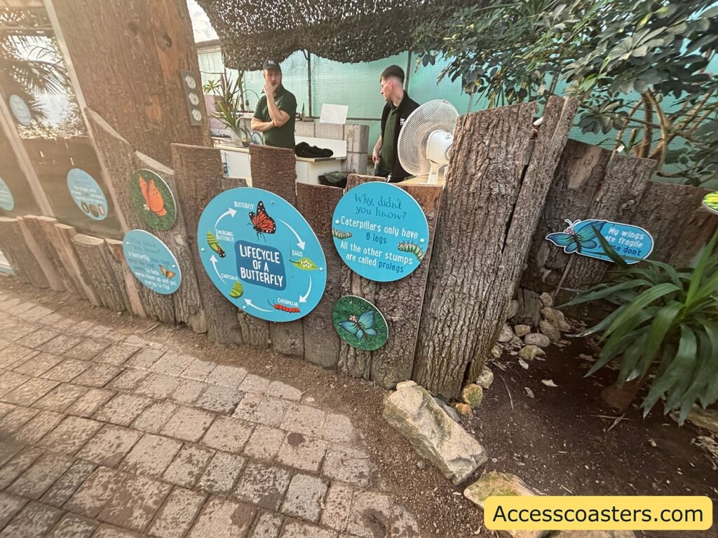 Small information counter with circular themed signs on the front; staff are behind the counter (details unclear).

