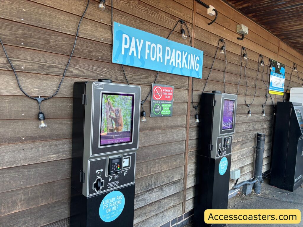 Pay-and-display style parking payment machines mounted on a wooden wall under a “Pay for parking” sign.
