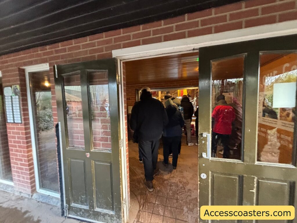 Indoor gorilla viewing area entrance with wide double doors; a small crowd walks inside.
