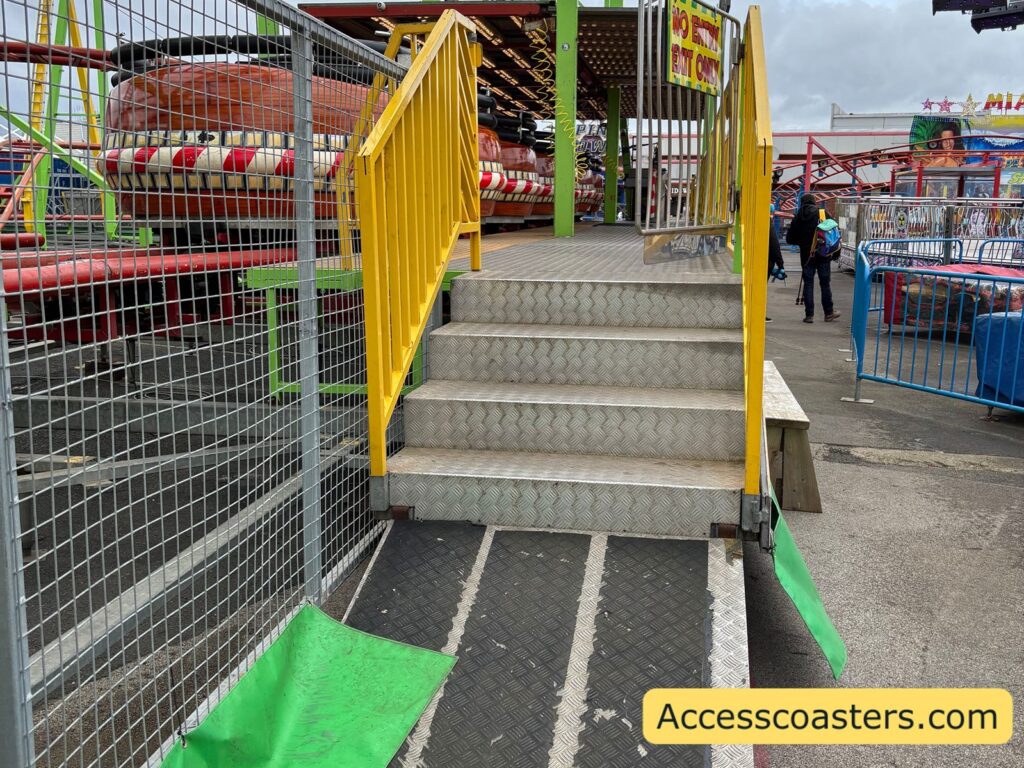 exit for the spinning coaster with set of metal steps with handrails leading down from the platform