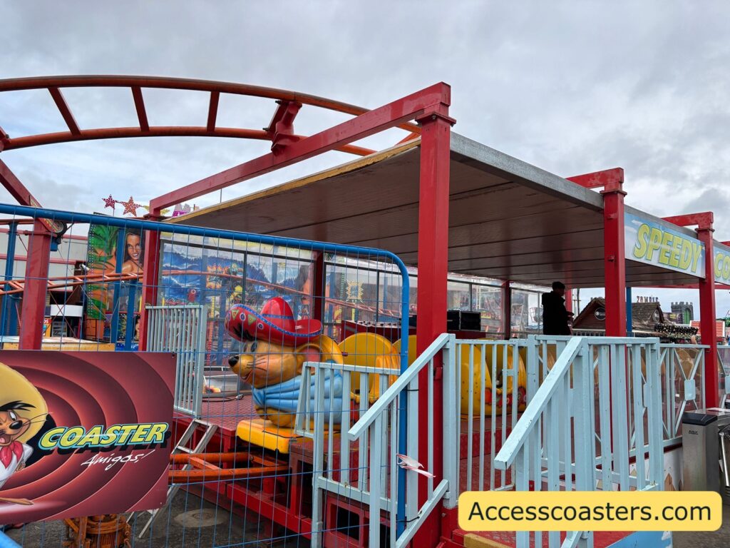 Side view of the Speedy Coaster station with part of the coaster train in the station.
