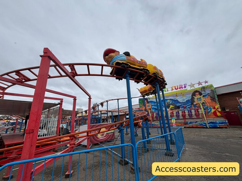 The Speedy Coaster train shaped like a colourful caterpillar traveling along the elevated red track