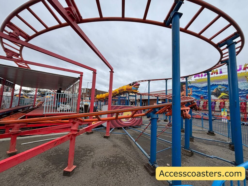 Curving section of the Speedy Coaster’s red track with supports, showing tight bends and a simple, compact junior coaster layout.