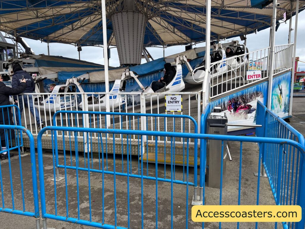 turnstile barer with digital screen to tap fun card leading to blue queue railings toward the loading platform of the Matterhorn ride