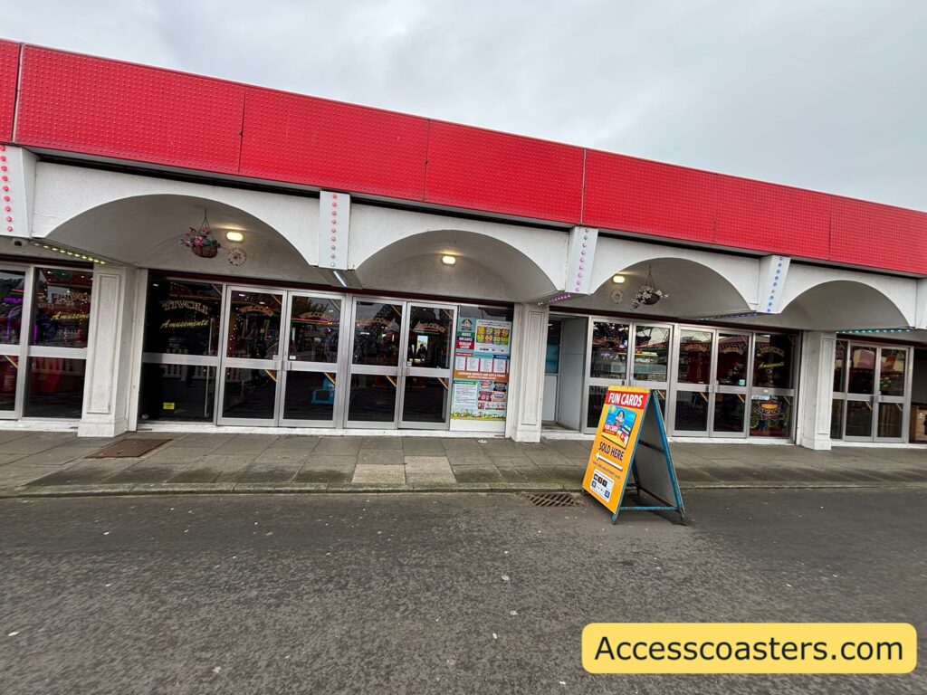 Front exterior of the arcade building with silver doors and a red roof fascia, location to collect carer wristbands