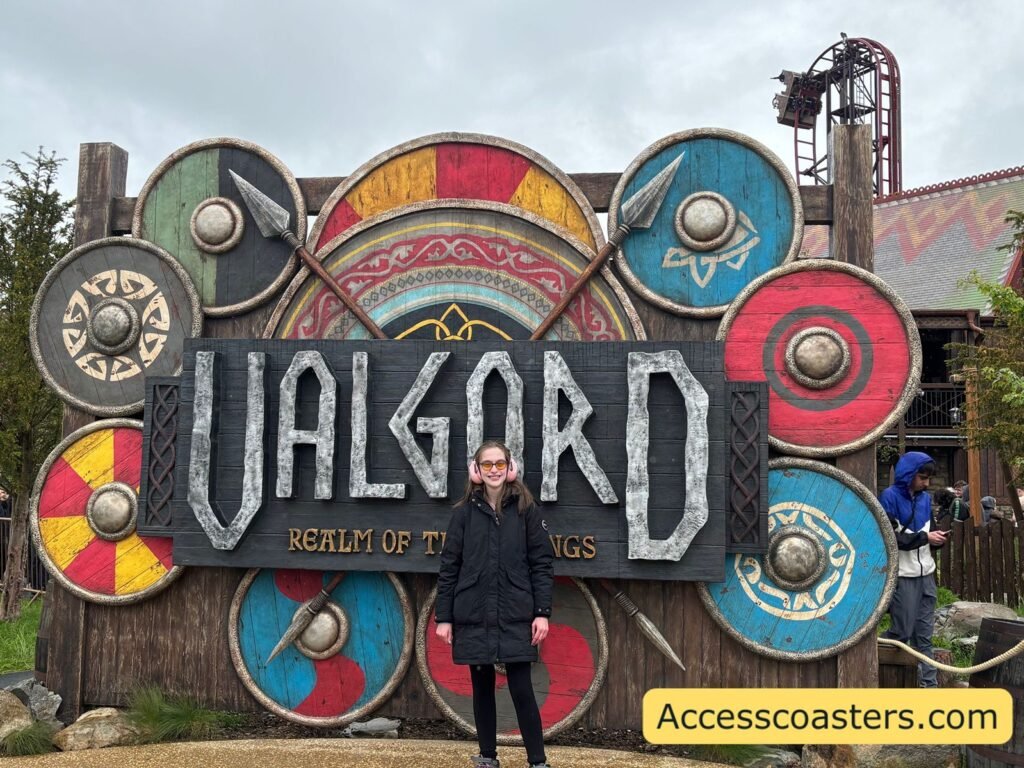 image of Iona stood posing Infront of Valgrd sign with viking shields all around. 