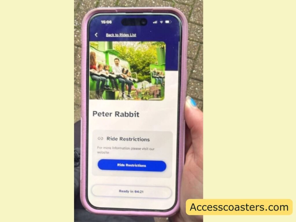 Smartphone showing a ride access pass app. The screen has a “Back to Rides List” header, a photo of riders on a green ride, the ride name “Peter Rabbit,” a “Ride Restrictions” section with a blue “Ride Restrictions” button, and a status line at the bottom indicating a ready time.