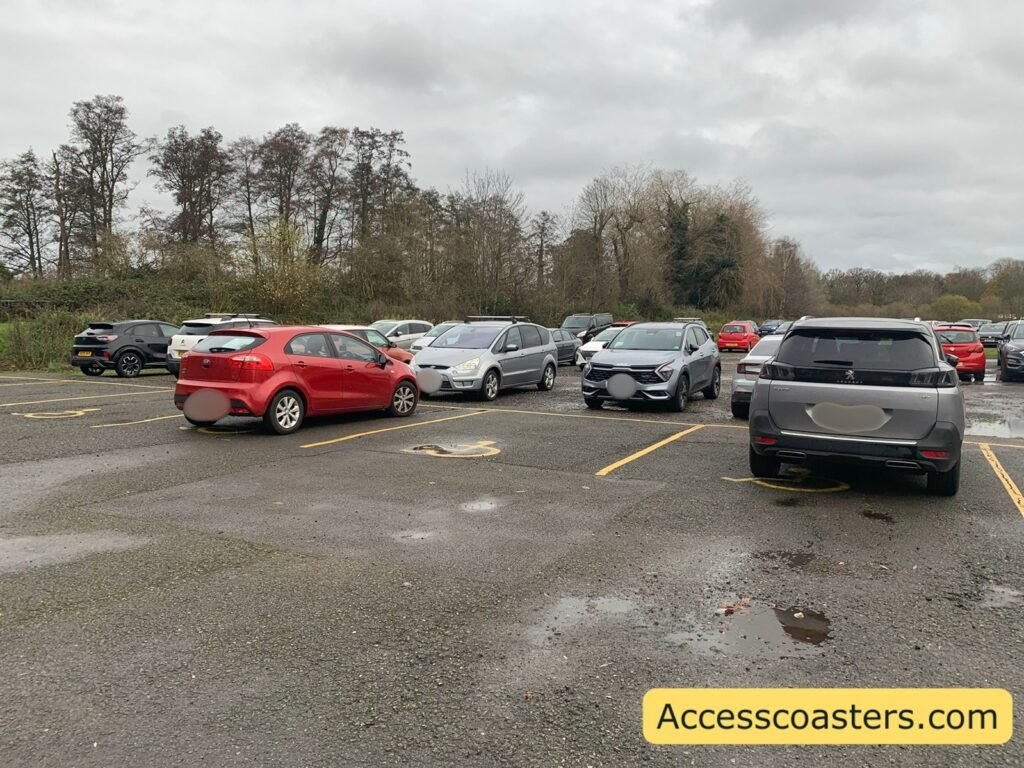 Image of tarmac car park with yellow blue badge parking spaces you can see cars parked in the car park.