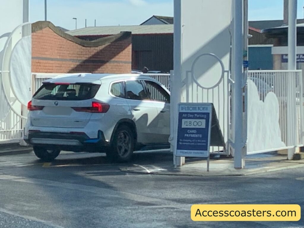 car entering the car park through the white entrance gates with ticket boof and pricing sign present