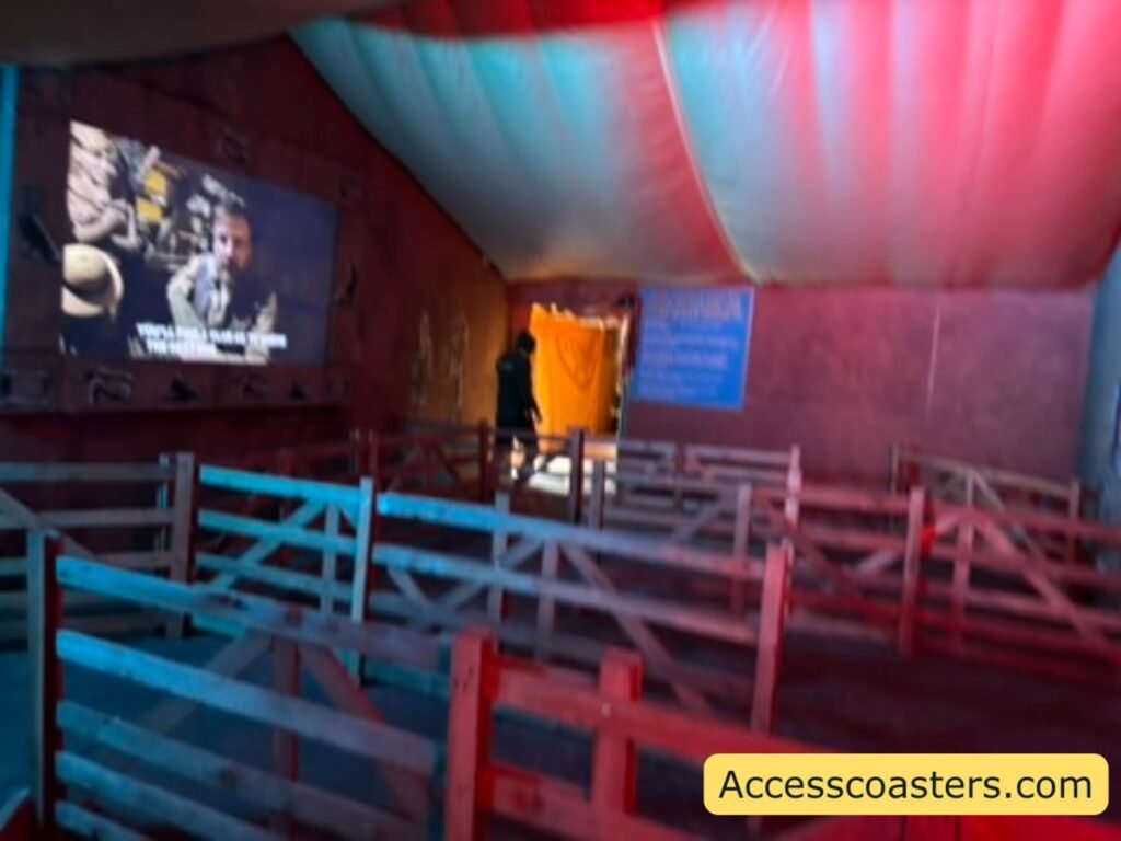 image shows wooden fenced queue line with a video projected on the wall. 