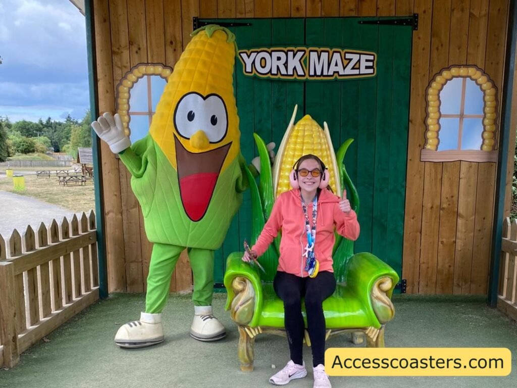 image of Iona sat on a green throne with a corn backrest posing for a picture next to Kernel Kernel