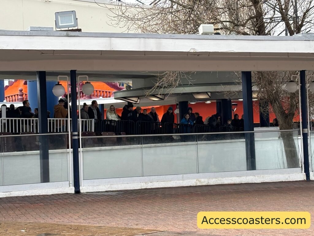 Side view of the Grand National station from outside the fence, showing guests waiting on the platform underneath the canopy.

