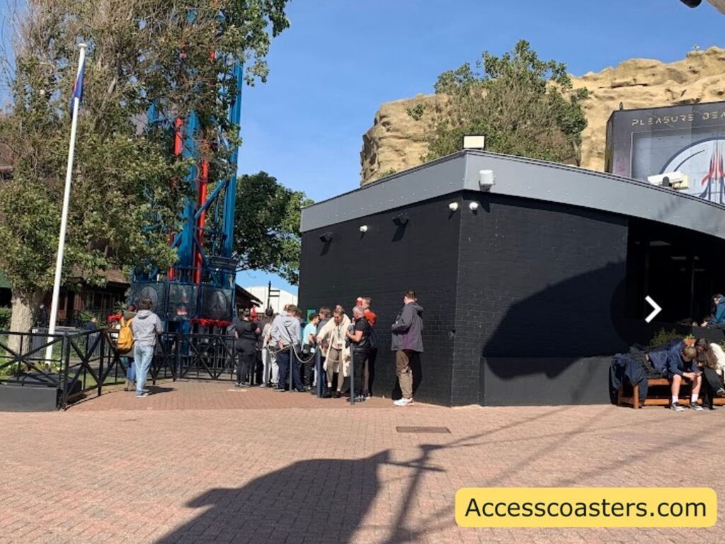 easy access pass entrance with people weighting locates to the left of a black queue line building.