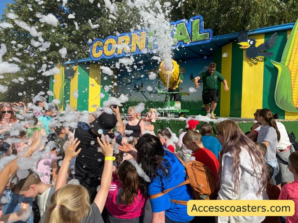 image of large crowd gathered by the Cornival  stage with a corn themed fome cannon being turned into the crowd. 