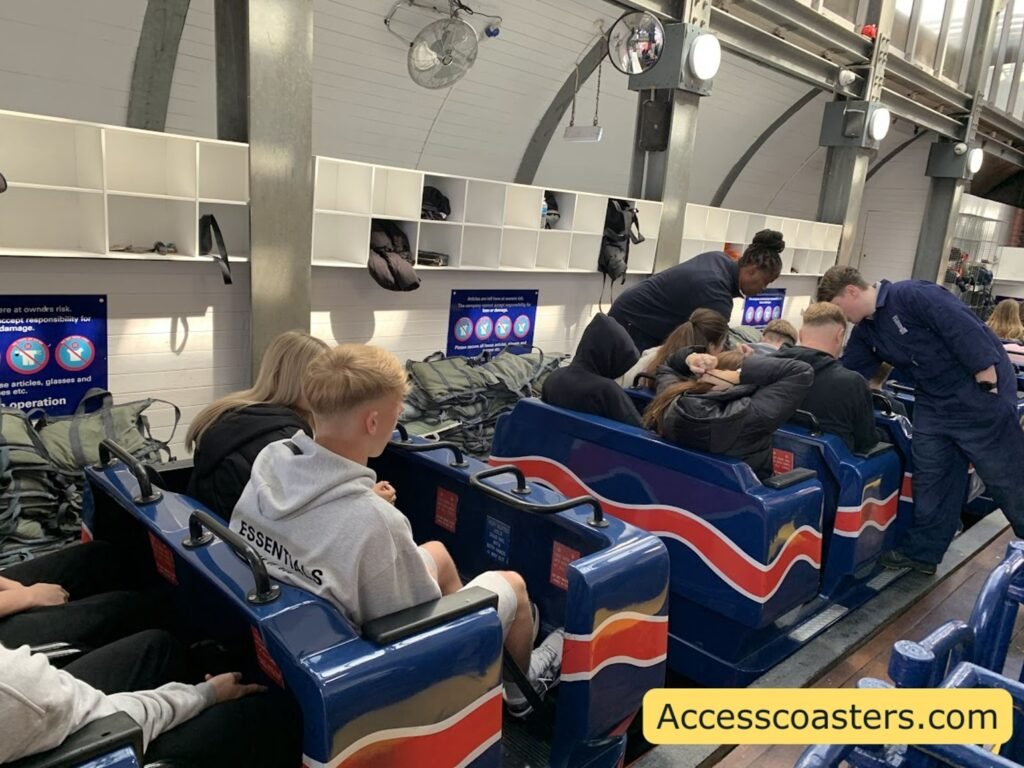 Boarding area of the Big One with guests in blue and red trains inside the station
