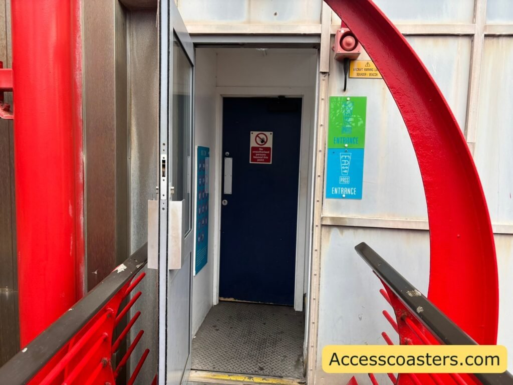 Doorway for the easy access pass route beside bright red coaster supports, leading into the internal stairs